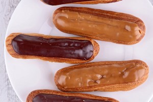 Chocolate and caramel eclairs with whipped cream filling